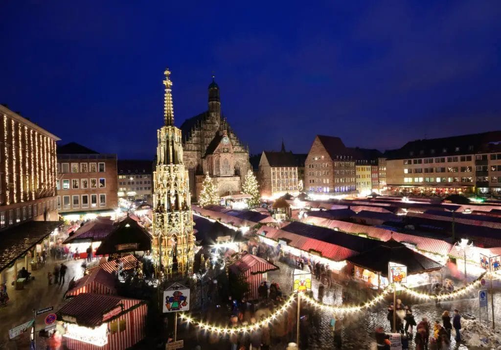 BEST CHRISTMAS MARKETS IN GERMANY - View over the Christkindelmarket in Nuremberg at night with Christmas Lights