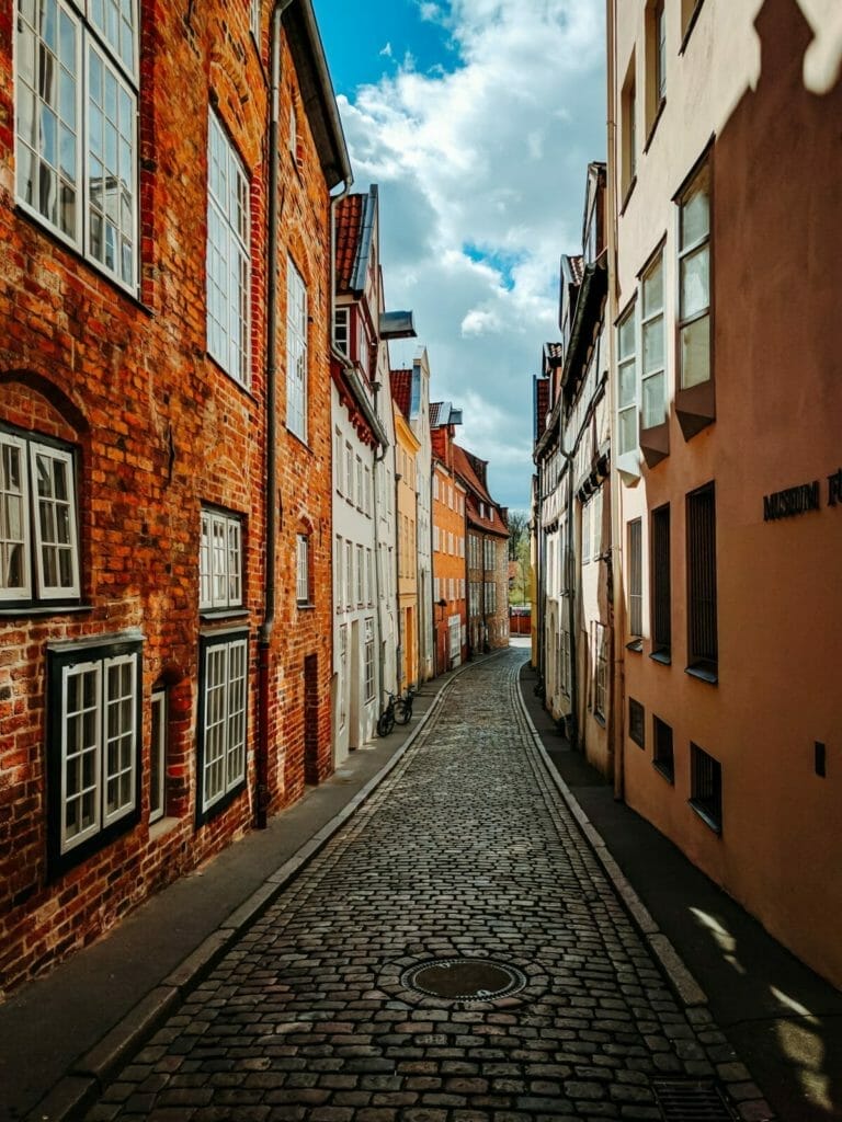 Sehenswerte Städte in Deutschland - Gasse in Lübeck mit Kopfsteinpflaster und bunten Häusern