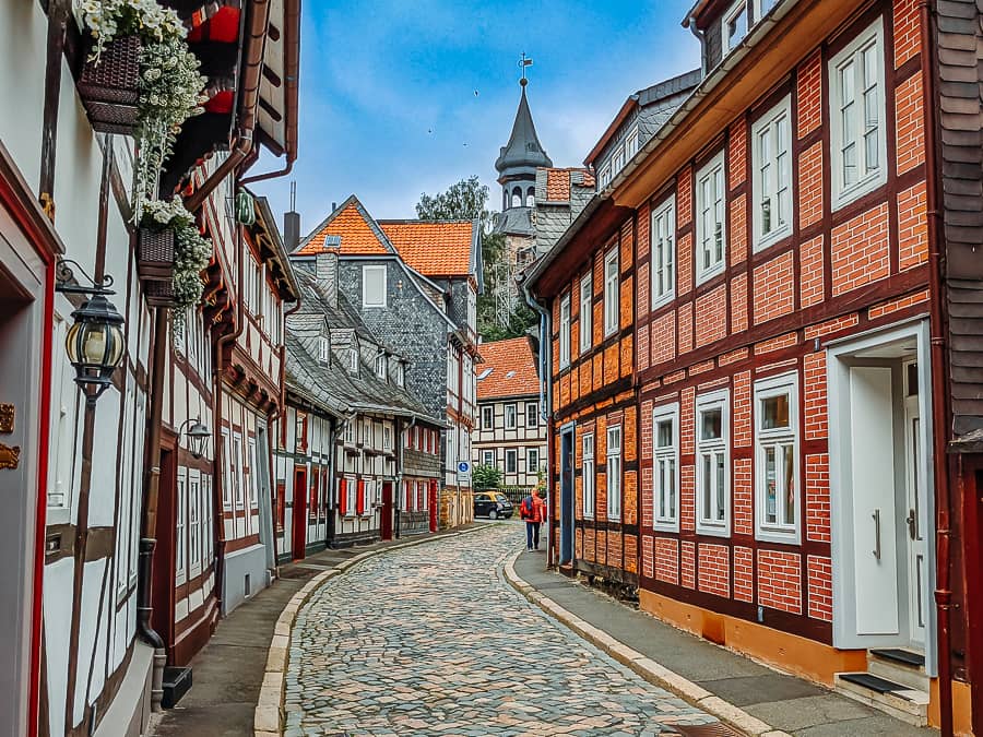 Goslar Sehenswürdigkeiten - Kopfsteinpflasterstrasse mit Fachwerkhäusern. Am Ende ist eine Kirche zu sehen