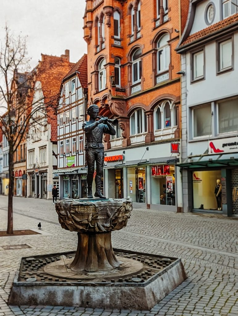 Die Statue des Rattenfängers steht zentral in einer Einkaufsstraße in der Hamelner Innenstadt - Hameln Sehenswürdigkeiten