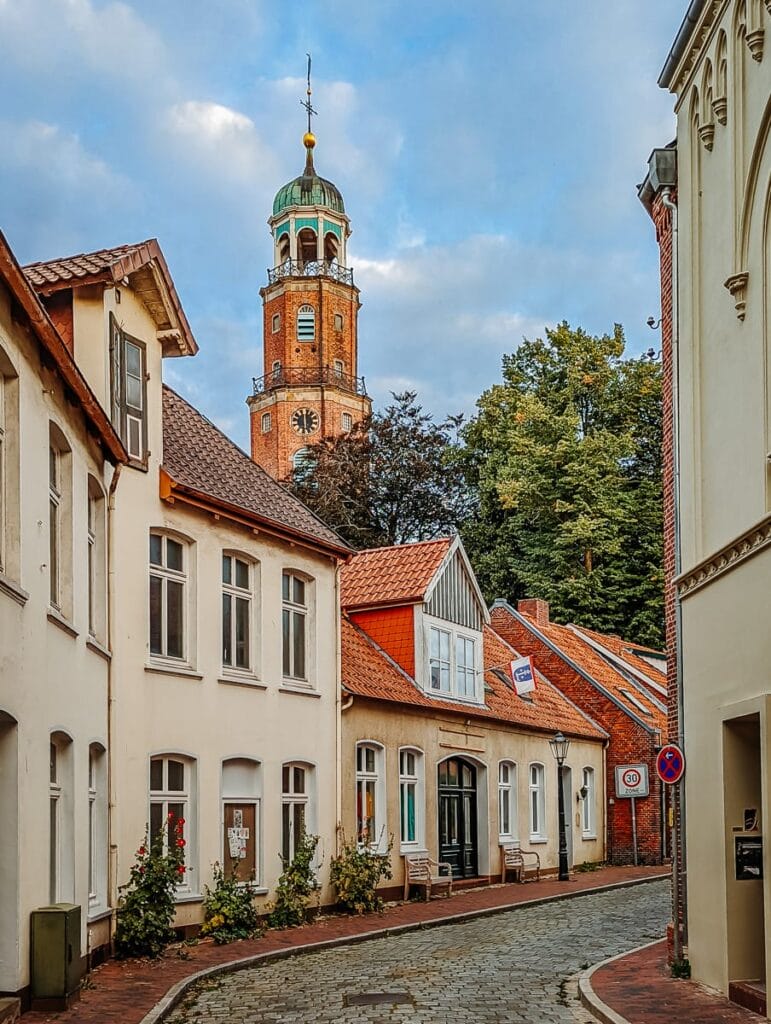 Gasse in der Altstadt mit dem Kirchturm der großen Kirche im Hintergund - Sehenswürdigkeiten in Leer